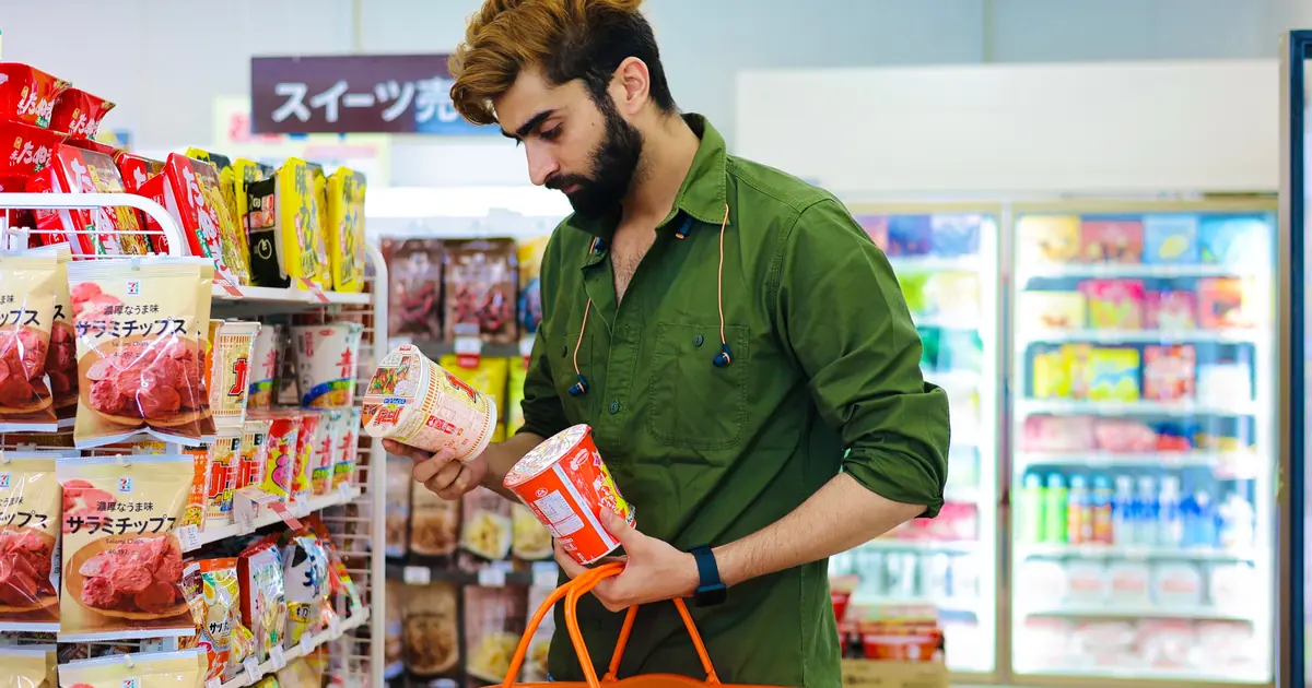 Cat owner comparing bags of cat food on a pet store shelf to choose the right one